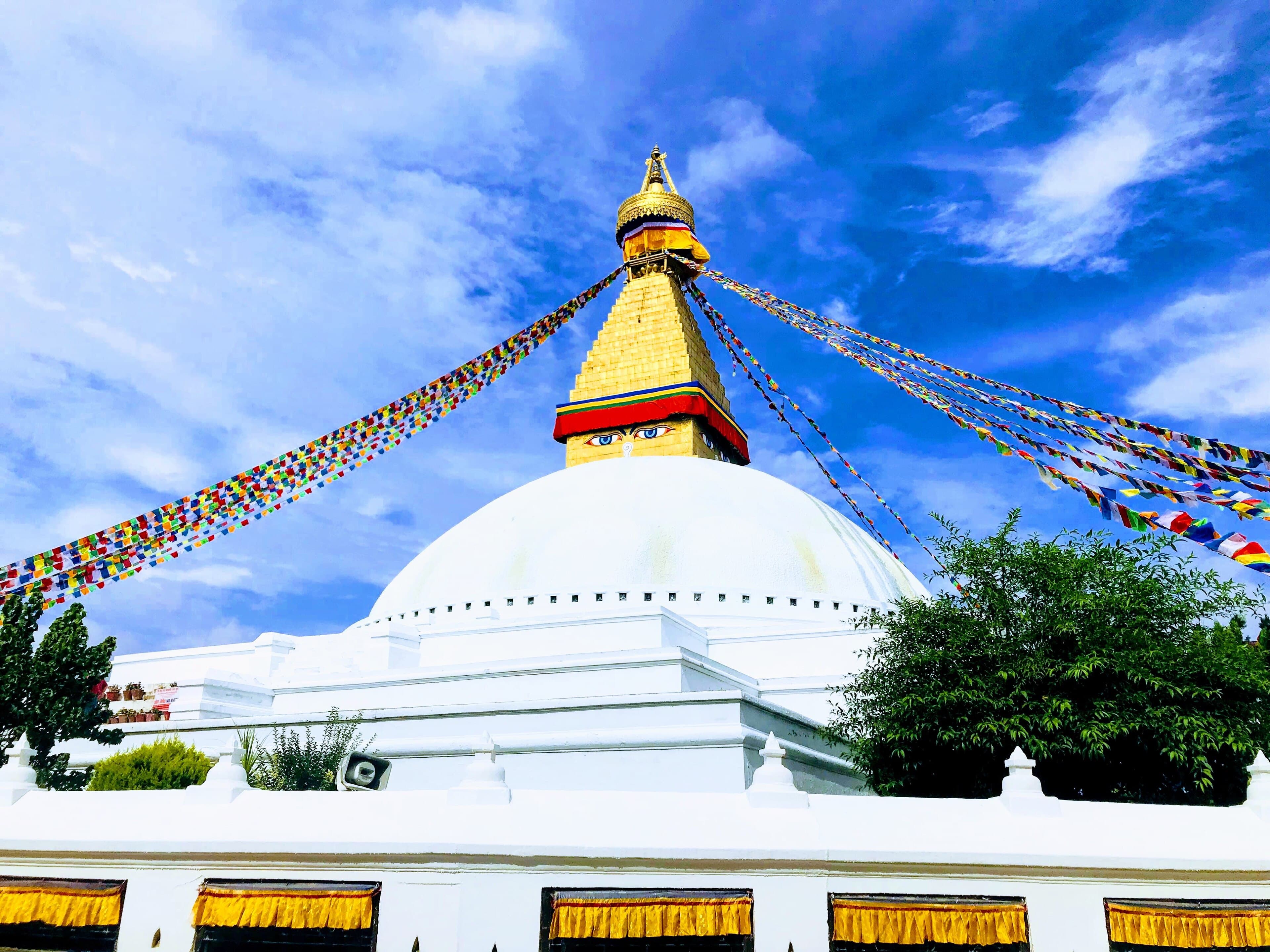 The Boudhanath stupa and its prayer flags under a bright sky
