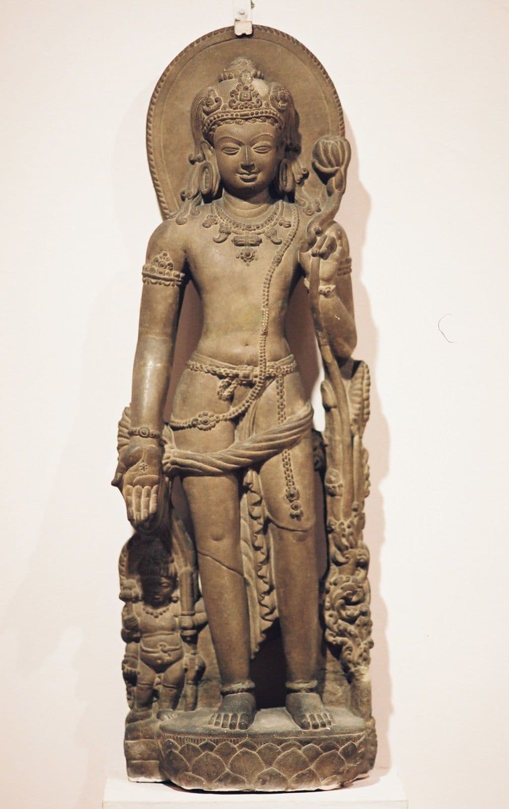 Ancient Indian stone statue of Avalokiteshvara, the bodhisattva of compassion, holding a lotus