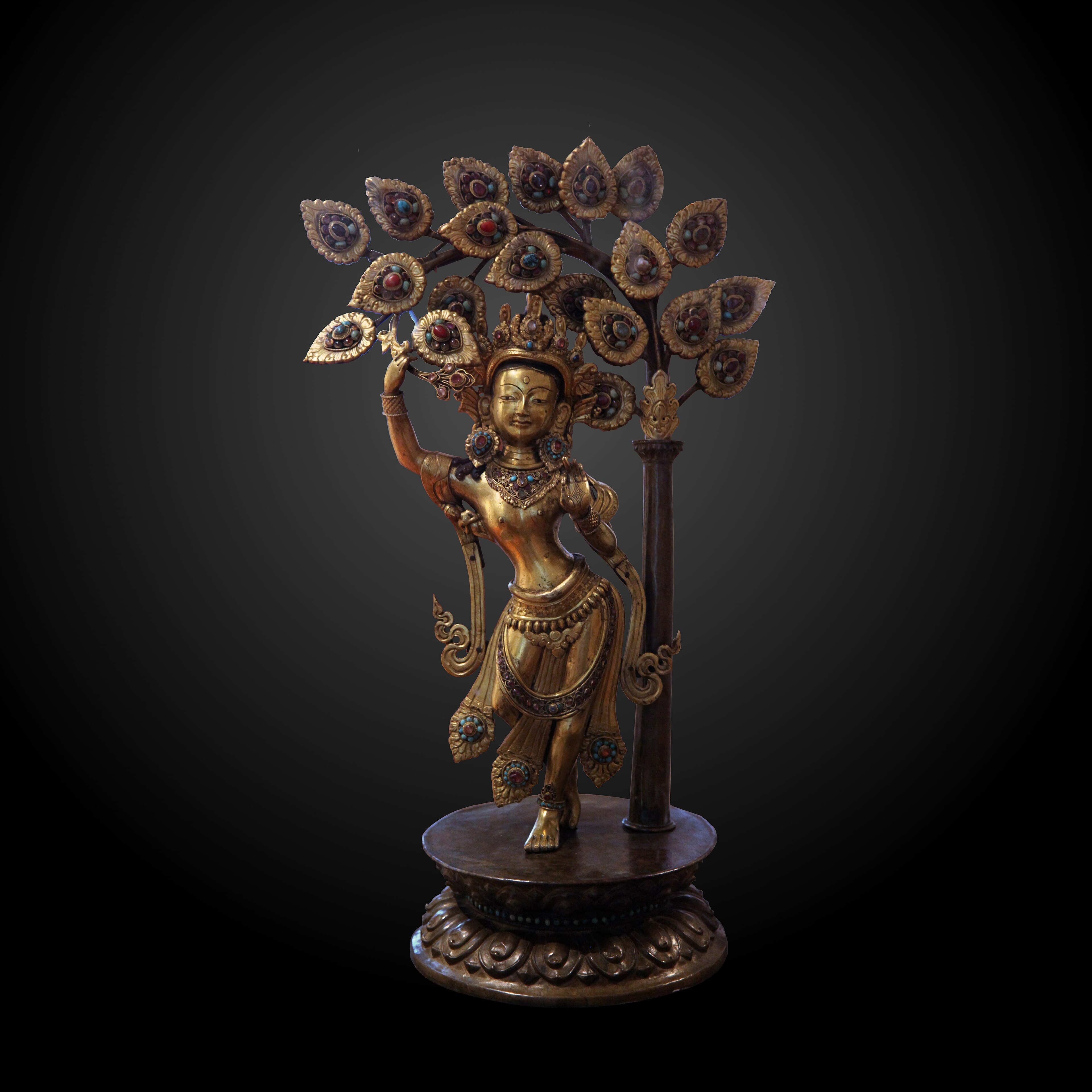 Gilt bronze statue of Queen Mayadevi reaching up to hold a branch of the sal tree at the moment of the Buddha's birth