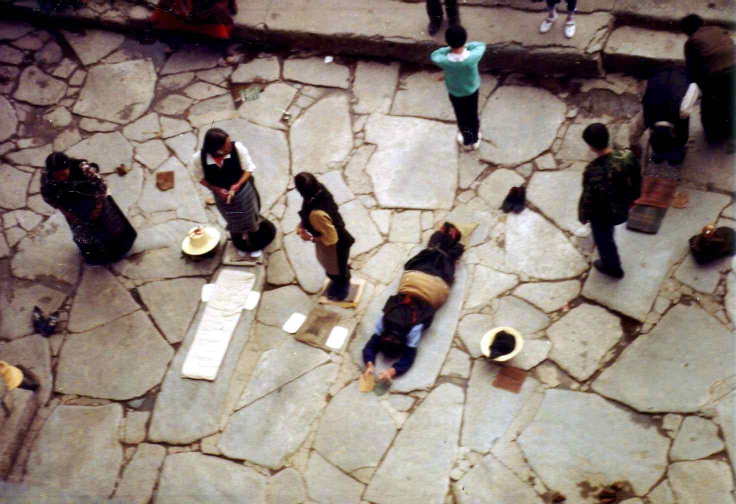 Pilgrims performing full-body prostrations outside the Jokhang Temple, Lhasa