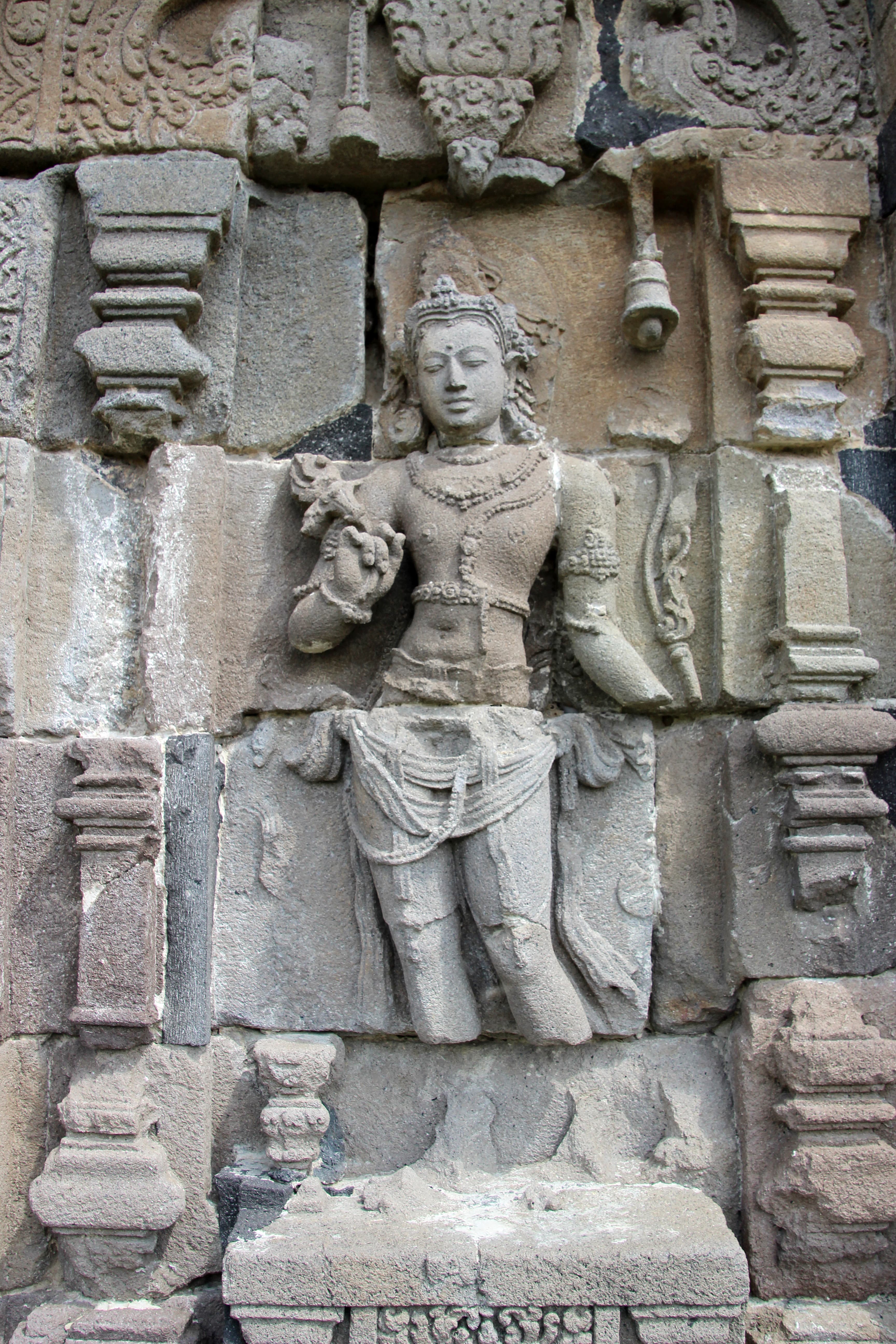 Stone relief carving of a bodhisattva on a Central Javanese temple wall